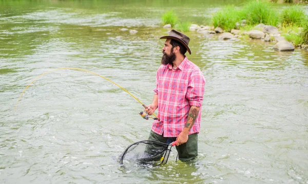 Fim de semana. Grande jogo de pesca. pescador com vara de pesca. pescador barbudo na água. hobby e atividade esportiva. Pothunter. homem maduro voar pesca. Homem a pescar peixe. Táxi peixe — Fotografia de Stock