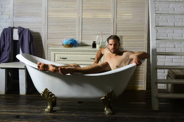 Macho assis nu dans la baignoire avec un look concentré — Photo