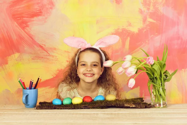 带着铅笔、鸡蛋、花，长着小兔子耳朵的快乐的东方女孩 — 图库照片