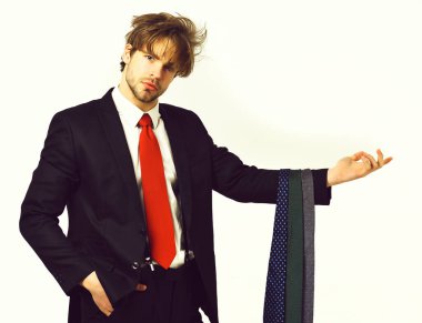 Sakallı, maço, şık takım elbiseli, kravatlı bir adam.