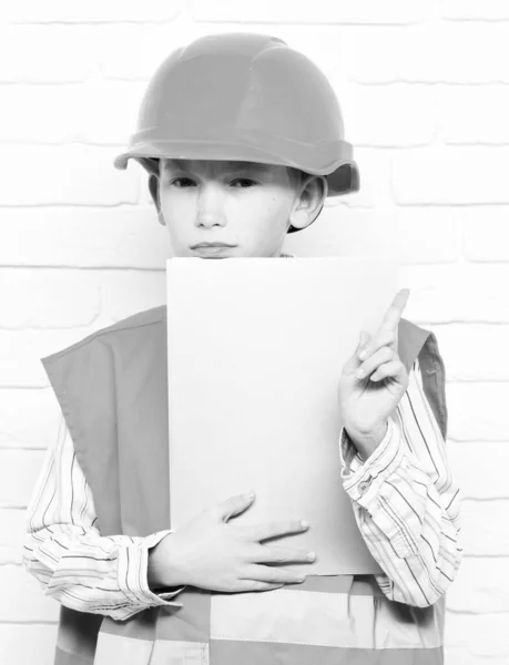 흰 벽돌 벽 배경에 있는 귀여운 어린 건축가 소년 — 스톡 사진