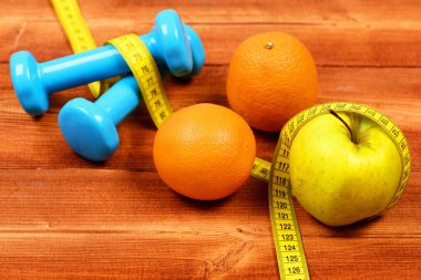 metre bant dumbell ağırlık, elma, portakal, diyet kavramı ile