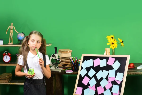 Παιδική ηλικία και μελέτη έννοια του χρόνου. Κορίτσι κρατά πράσινο ρολόι — Φωτογραφία Αρχείου