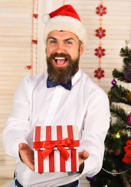 Mann mit Bart und Fliege hält gestreifte Geschenkschachtel — Stockfoto