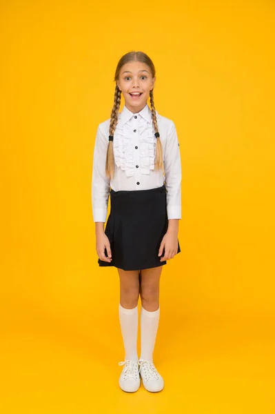 Uma estudante perfeita. Pequena colegial com sorriso feliz. Pequena colegial bonita em uniforme escolar. Estudante bonito com cabelo comprido. Bem-vindo de volta à escola. Conceito de graduação. Ensino primário — Fotografia de Stock