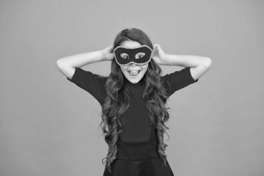 Karnaval eğlence dükkanı. Mutlu çocuk eğlence için Venedik maskesi takıyor. Küçük kız gizemli turuncu geçmişiyle eğleniyor. Havalı maskeli balo eğlencesi. Tatil kutlaması. Parti ve eğlence