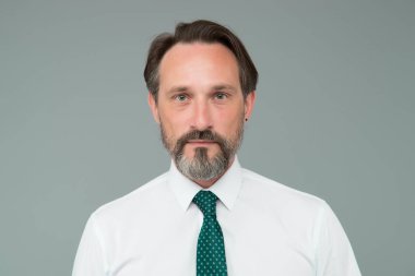 Klas bir örnek. Yakışıklı, kendine güvenen, olgun model beyaz gömlek giyiyor. Özgüven duygusu. Beyefendiler. Erkek modası. Moda dükkanı. Sakallı, olgun bir yüz.