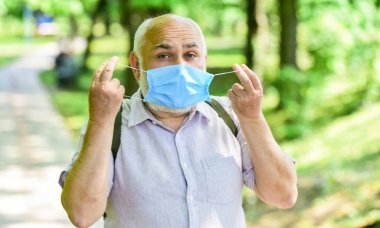 Maske virüsten korunuyor. Salgın hastalık konsepti. Enfeksiyonun yayılma riskini sınırla. Kıdemli adam maskesi. Yaşlı insanlar yüksek riskli covid-19. Maske tak. Karantina genişletildi. Kilitleme kısıtlamalarının hafifletilmesi