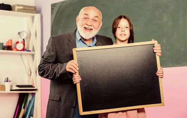 A Better Way Found. mature teacher and happy pupil girl. small girl with man tutor study. blackboard for information and announcement. Copy space. school classroom. empty chalk board. School sales — Stock Photo, Image
