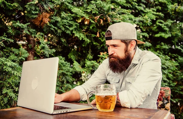 Bilgisayar teknolojisi hayatı kolaylaştırıyor. Hippi bira içiyor ve dışarıda laptop teknolojisi kullanıyor. Sakallı adam iletişim teknolojisiyle iletişim kuruyor. Modern teknoloji — Stok fotoğraf