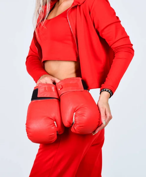 Never give up and keep moving. sports woman in tracksuit and boxing gloves. fit boxer woman. kick off. confident young sportswoman posing in boxing gloves. slim shaped woman with red boxing gloves Stock Image