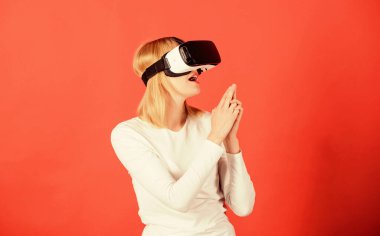 Şaşırmış genç bir kadın VR deneyimi sırasında havaya dokunuyor. Neşeli gülümseyen kadın VR gözlükleriyle bakıyor. 3D gözlük kullanan bir kadın heyecanlı. E sporu.