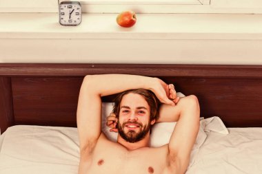 Sabah uyandıktan sonra gerin. Koyun altından dışarı bakan çıplak ayaklı bir adam. Uykulu adam pazartesi sabahı çalar saat sinyalini duyduktan sonra erken kalkıyor..