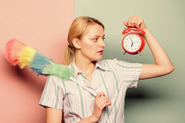 Mükemmeliyetçilik konsepti. Kadın elinde toz fırçası çalar saati tutuyor. Her şey mükemmel olmalı. Kız mükemmeliyetçi. Mükemmeliyetçi kompleksi. Obsesif kompulsif bozukluk. Temizlik zamanı. Saplantılı mükemmeliyetçi