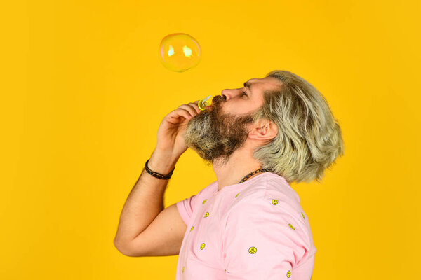 Infantility concept. Carefree man soap bubbles. Summer vacation. Happy playful bearded hipster and soap bubbles. Happiness and joy. Good vibes. Blow inflate bubbles. Forever young guy. Positive