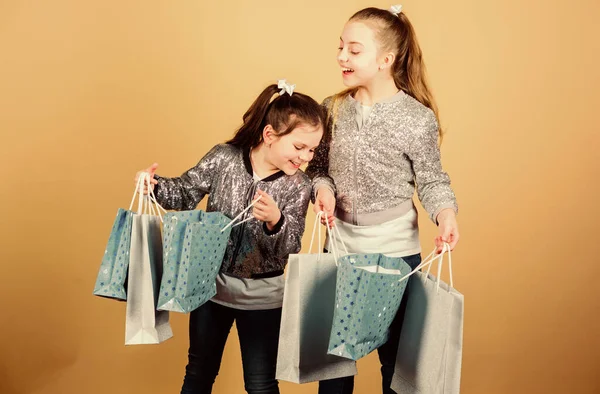 Sexta-feira negra. Venda e desconto. Dia das compras. As crianças têm muitos pacotes. Moda infantil. Esperar mais. Paga menos. Meninas irmãs amigos com sacos de compras fundo bege. Compras e compras — Fotografia de Stock