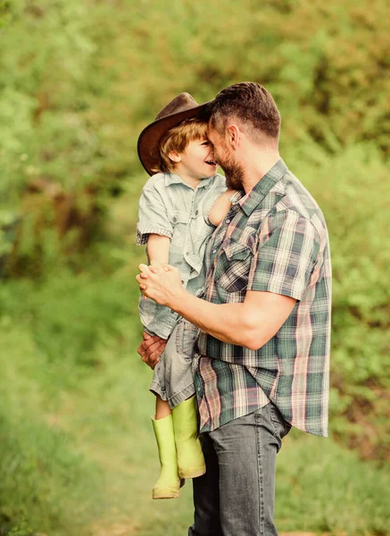 Child having fun cowboy dad. Farm family. Holidays at parents farm. Growing cute cowboy. Weekend at farm. Little helper in garden. Little boy and father in nature background. Spirit of adventures — Stock Photo, Image