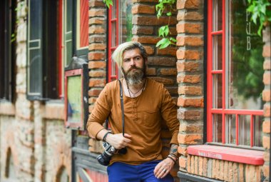 Seni bekliyordum. Sakallı hippi adam fotoğraf çekiyor. Açık havada fotoğraf çekimi. Geçmişe dönük kamerası olan vahşi bir gezgin. Modern hayatta fotoğrafçılık. Seyahat ipuçları. Profesyonel fotoğrafçı klasik kamera kullanır.