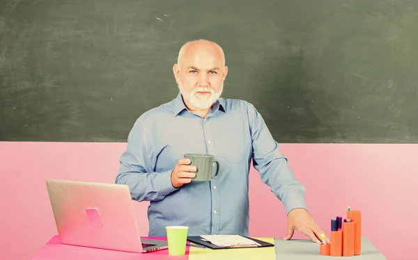 college professor. school lesson break. Mature teacher man with coffee cup. senior man teacher with notebook and computer. back to school. Education concept. tutor in classroom. Making notes