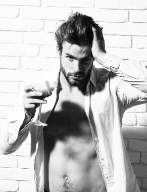 Beyaz tuğla duvarda yakışıklı, sakallı, maço seksi bir adam.