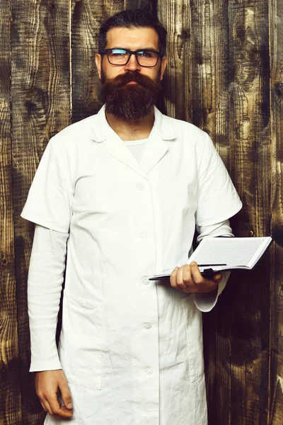 Bearded brutal caucasian doctor or postgraduate student with notebook