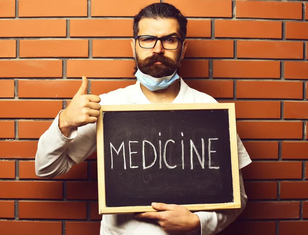 Brutalny, biały lekarz trzymający deskę z napisem "Lekarstwo" — Zdjęcie stockowe