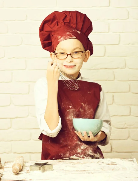 Foltos aranyos szakács fiú fehér tégla fal háttér — Stock Fotó