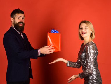 Kırmızı arka planda duran mutlu genç çift.