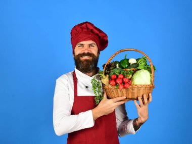 Şef lahana, turp, marul, biber ve sarımsaklı brokoli tutuyor.