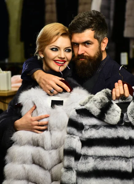 Fashion and shopping. Couple in love tries expensive sable overcoats