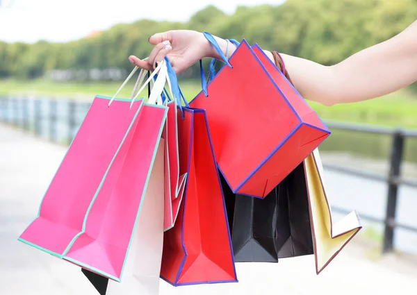 Colorful paper bags in hands of woman. Shopping and sales