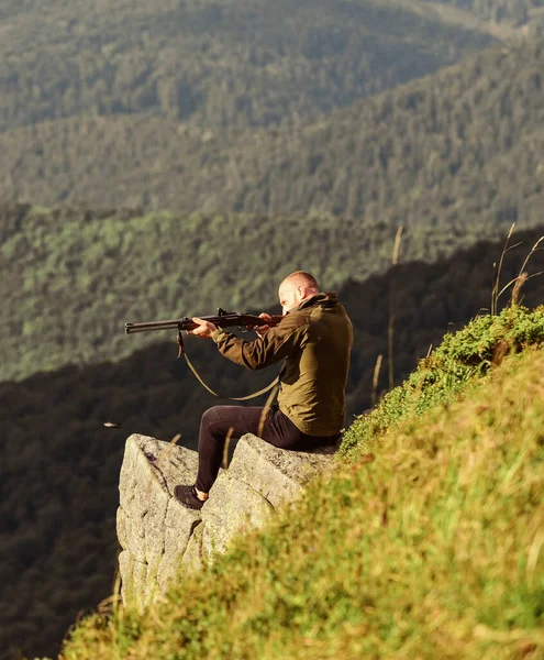 Hunter hold rifle. Hunter spend leisure hunting. Hunting in mountains. Man brutal gamekeeper nature landscape background. Hunting masculine hobby concept. Regulation of hunting. Focused on target — Stock Photo, Image