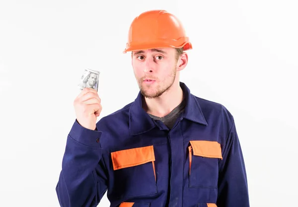 Bouwer verdient geld, reparateur houdt contant geld vast, gerolde bankbiljetten in de hand. — Stockfoto