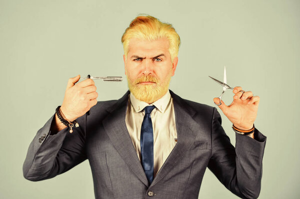 Бородач держит бритвенные ножницы. Парикмахерская. Хипстер с инструментами. Разрабатываю стрижку. Свежая прическа. Концепция парикмахерской. Парикмахерская. Блондинка. Отбеленные волосы. Парикмахер-стилист
