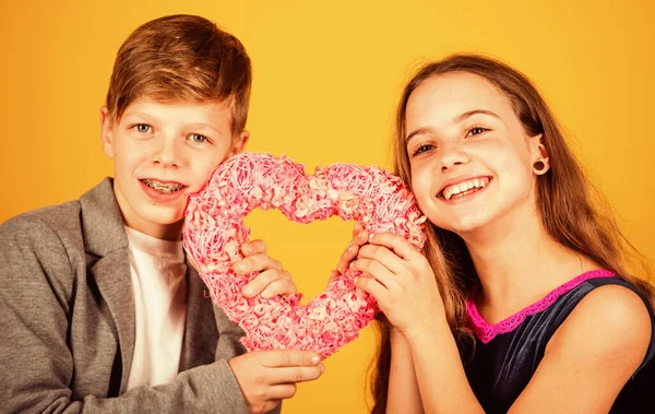 Ven a vivir en mi corazón. Los niños felices sostienen el fondo amarillo rosado del corazón. Regalo para San Valentín. Tienda de regalos. Comprando regalos. Amor y amistad. El único regalo que puedo darte es mi corazón. — Foto de Stock