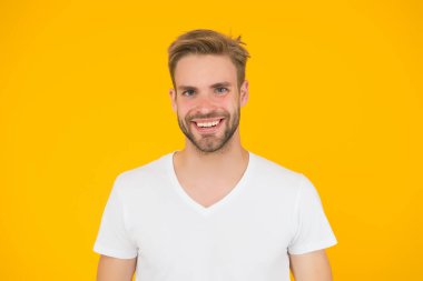 Yakışıklı, seksi adam. Karizma konsepti. Yüz bakımı. Güzel insanlar. Yakışıklı genç adam. Tıraşsız yakışıklı bir adam. Tüylü hippi beyaz tişört giyer. Yakışıklı adam poz veriyor. Karizmatik maço