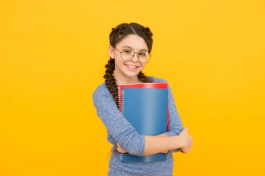 Kütüphane yaratıcılığı geliştirmeye odaklandı. Mutlu kız kütüphane kitaplarını tutuyor. Yürüyen ansiklopedi. Okul kütüphanesi. Bilgi ve bilgi. Bibliopol. Kitapçı. Çocukluk hayal gücü kütüphanesi