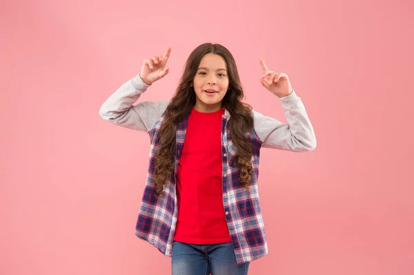 Sigue tu sueño. Niña apuntando hacia el fondo rosa. Niño pequeño en ropa casual. Belleza mirada de niña linda. Tendencia de moda. Estilo de moda. El cuidado infantil y la infancia. Día de los niños — Foto de Stock