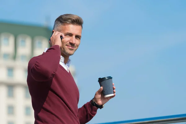 Relajante. Hombre con teléfono inteligente y taza de café al aire libre. Beba café y relájese. Rituales diarios. Hora de llamar a la familia. Hora del almuerzo. Pausa para el café y conversación agradable. Llamada móvil. Navegación por Internet — Foto de Stock