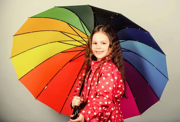 비옷입은 작은 소녀. 비를 막아주는 장치. 레인보우. 가을 패션. 쾌활하고 명랑 한 성격의 어린이. 화려 한 우산을 두른 행복 한 어린 소녀. 영감을 기다림 — 스톡 사진