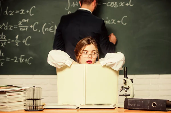 Thinking hard. Pretty teacher giving homework. Student writing homework on chalkboard. Doing homework together. Homework assignment and task. School and education. Teaching and learning — Stock Photo, Image