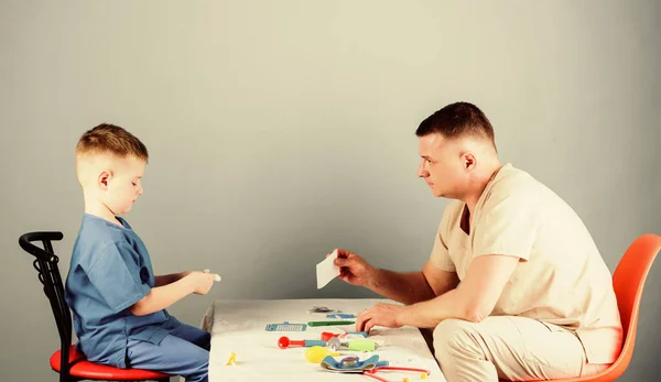 happy child with father with stethoscope. nurse laboratory assistant. family doctor. father and son in uniform. medicine and health. small boy with dad. pediatrician intern. fathers day. Happy baby