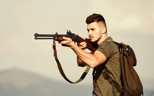 Um tipo bonito e caçador com arma. Hunter passa a caça ao lazer. Equipamento de caça. Passatempo masculino brutal. Homem observando fundo da natureza. Hunter segura na espingarda. Medidas de segurança. Ambiente natural — Fotografia de Stock