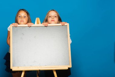 Mavi arka planda okul üniformalı kızlar