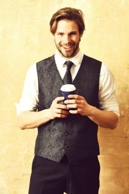 Takım elbiseli bir iş adamının elinde kahve kağıdı.