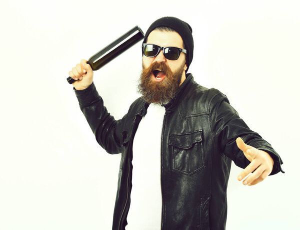 Bearded brutal caucasian hipster holding bottle on white studio background