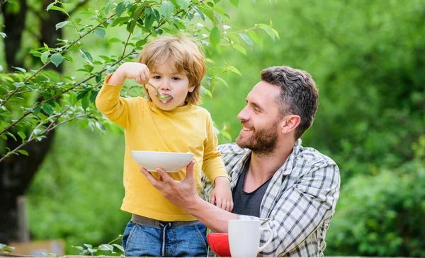 Best day ever. healthy food and dieting. Dairy products. happy fathers day. Little boy with dad eat cereal. father and son eating outdoor. family dinner time. Morning breakfast. Vegetarian diet — Stock Photo, Image
