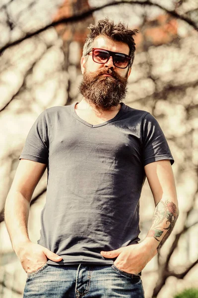 Homme barbu de lunettes de soleil fond nature. Homme barbu porter des lunettes de soleil modernes à la mode. Hipster confiant dans les lunettes de soleil sombres. Filtre UV. Homme barbu hipster brutal porter des lunettes de soleil de protection — Photo