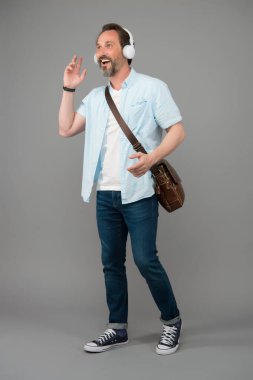 Müzikle her şey daha iyi. Mutlu adam müzik dinler. Olgun insan müzikten hoşlanır. Müzik kulaklığı sesi. Modern teknoloji. Şehir hayatı. Favori şarkılarla yürüyorum. Kablosuz kulaklıklar