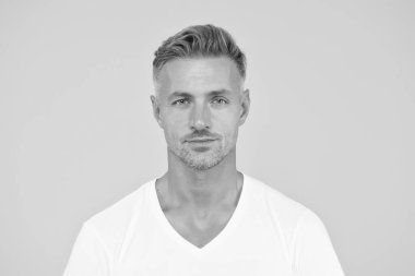 Yakışıklı ve karizmatik. Yakışıklı, sarı arka plan. Yakışıklı yüzlü, tıraşsız bir adam. Cilt ürünleri. Saç ve cilt bakımı. Saç bakım kozmetiği. Erkekler tımar ediliyor. Yakışıklı ve bakımlı.